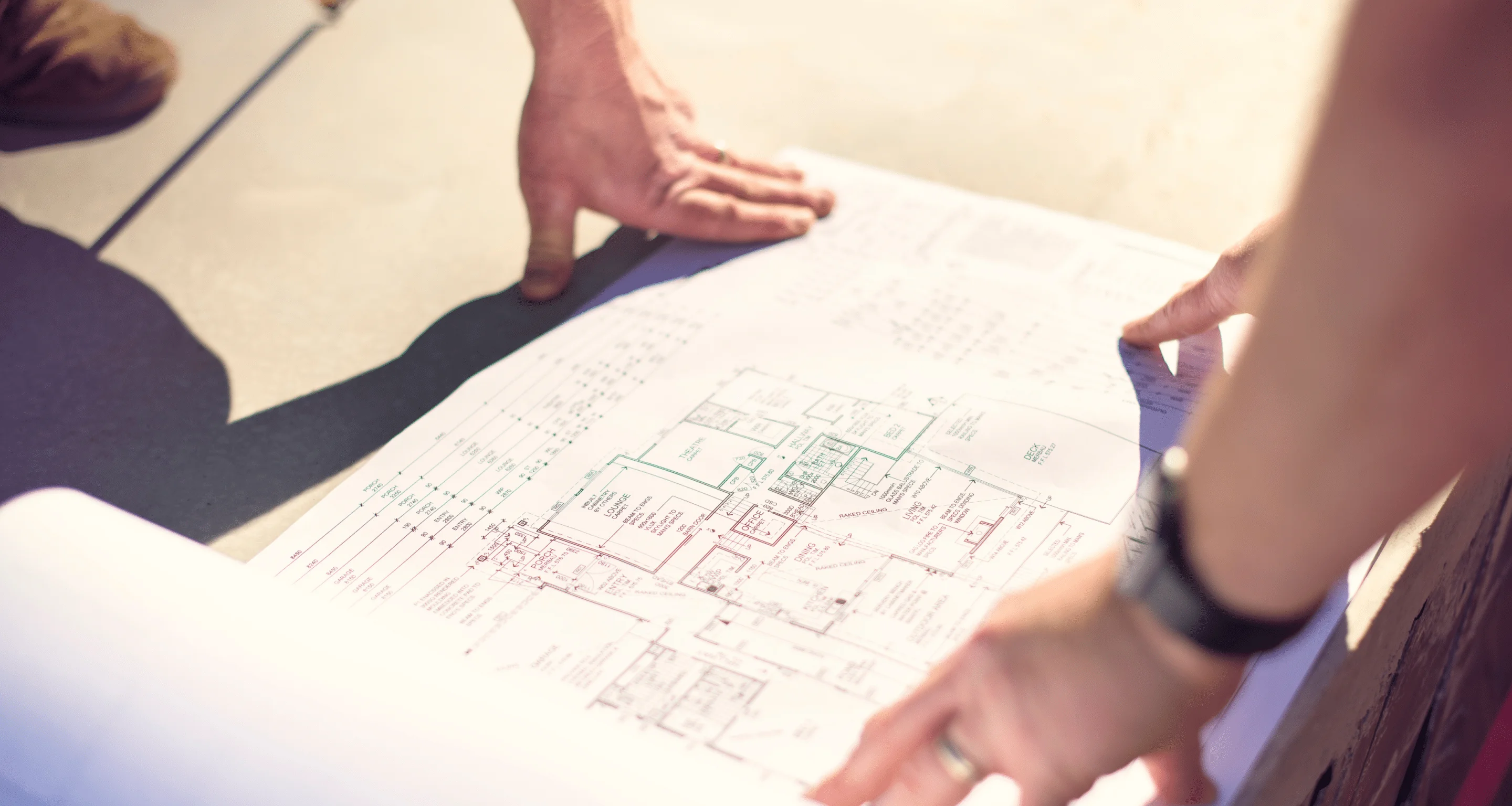 Photo of Jarrod standing above a floor plan for a home design
